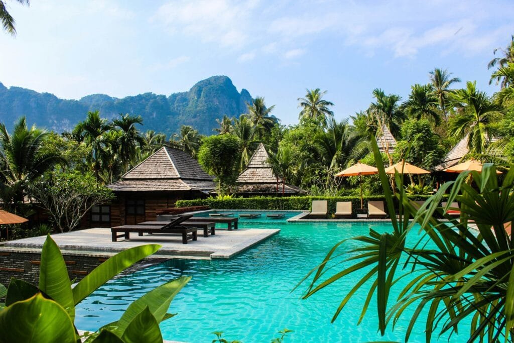 imagen muestra una hermosa piscina con instalaciones en medio de una selva paradisiaca podria ser en la polinesia, representando portales para buscar arriendos de verano