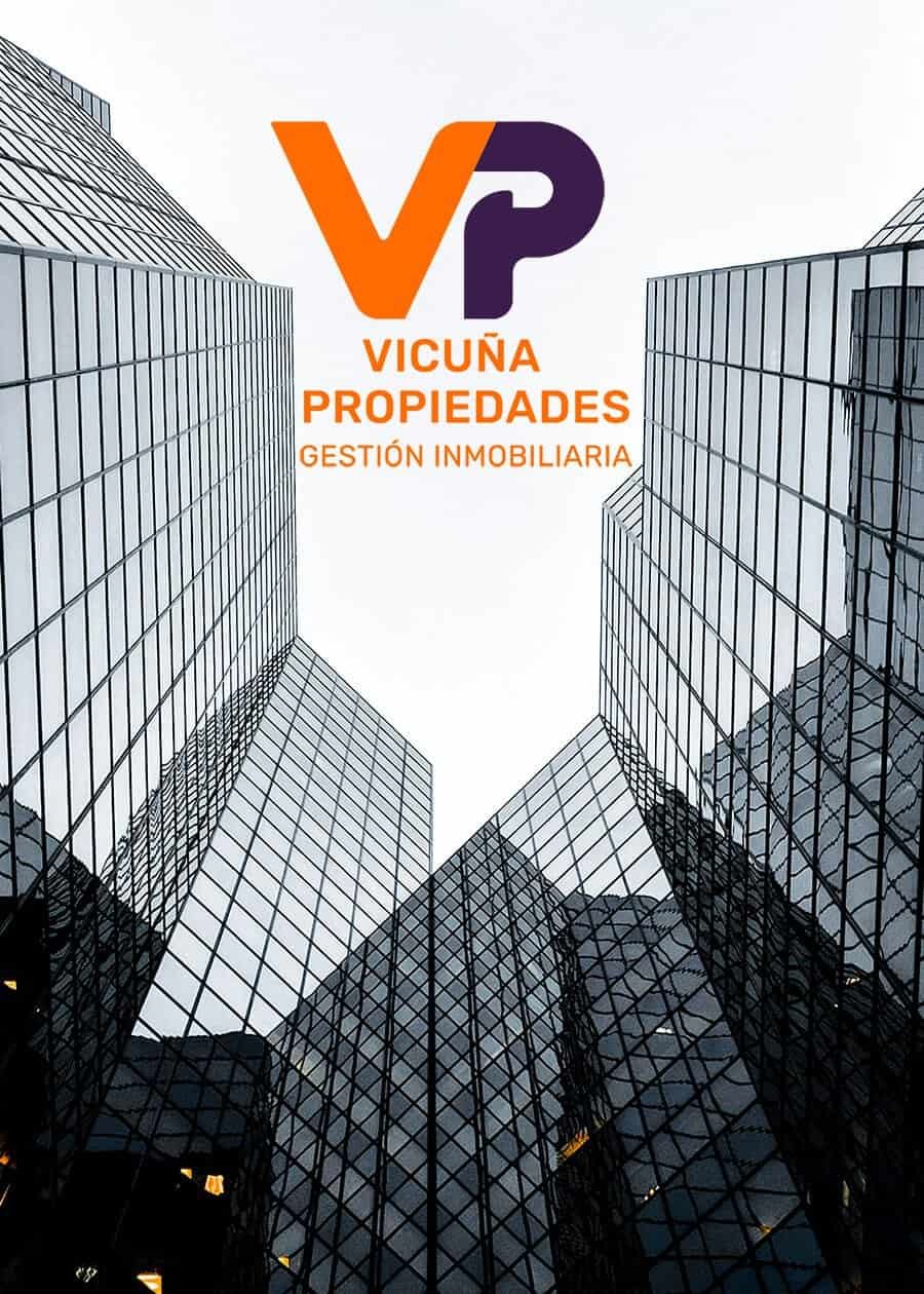 Imagen muestra un grupo de edificios tomados en plano contrapicado, se ve el cielo desde abajo y entre los edificios se ve el logo vicuña propiedades, representando el corretaje de propiedades vicuña propiedades Vicuña Propiedades